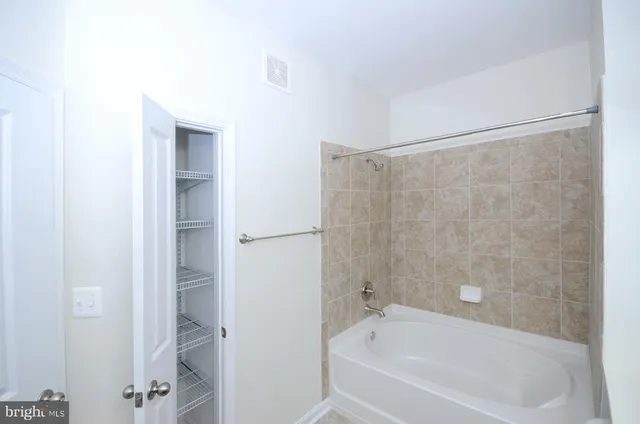 a white bath tub sitting next to a white sink and vanity