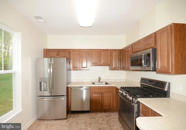 a kitchen with a stove a refrigerator and a sink
