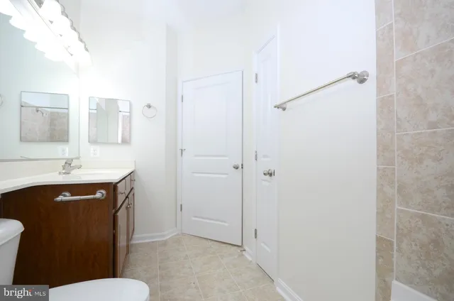 a bathroom with a sink a toilet a mirror and shower