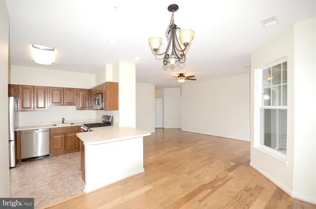 a kitchen that has a lot of cabinets and wooden floor