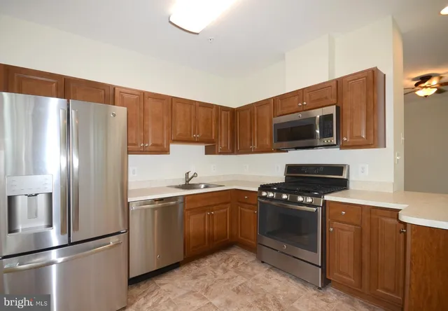 a kitchen with stainless steel appliances a refrigerator stove and microwave