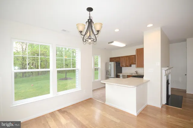 a kitchen that has a lot of windows and a chandelier