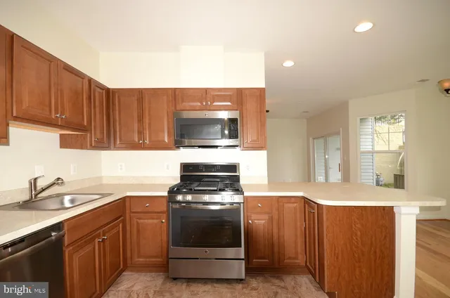 a kitchen with stainless steel appliances a stove a sink and a microwave