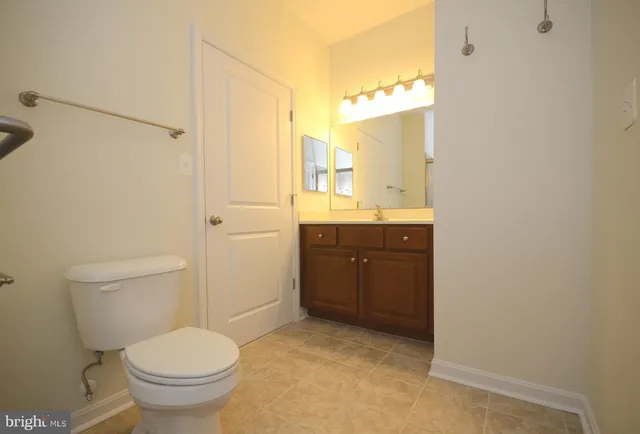 a bathroom with a granite countertop toilet sink and mirror