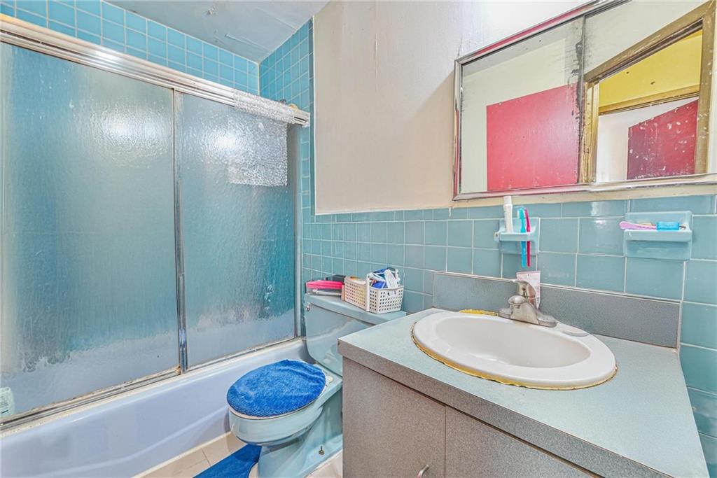 237 74th Street Brooklyn, NY 11209 - Photo 17 of 20 a bathroom with a sink a toilet and a mirror
