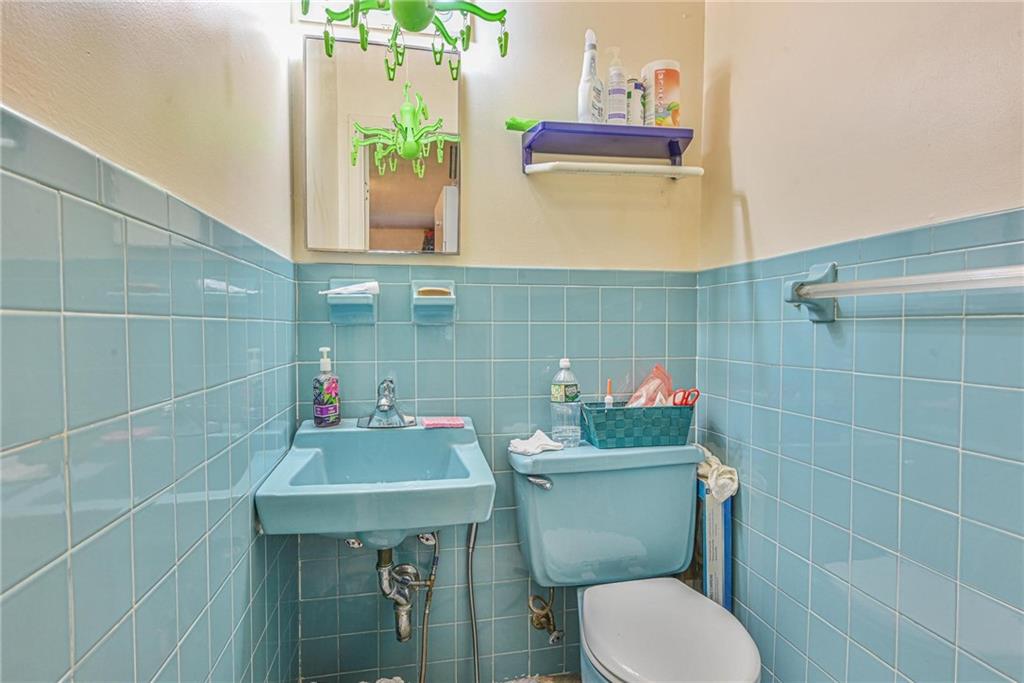 237 74th Street Brooklyn, NY 11209 - Photo 18 of 20 a bathroom with a sink a toilet and a mirror