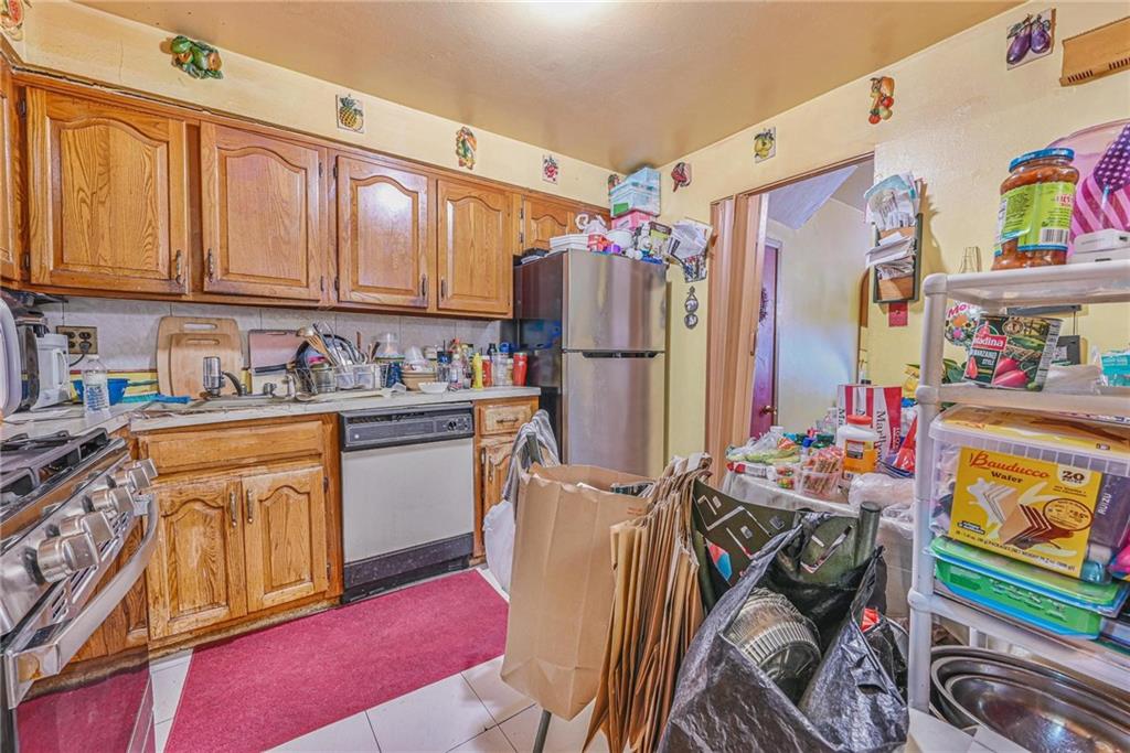 237 74th Street Brooklyn, NY 11209 - Photo 4 of 20 a kitchen with stainless steel appliances a stove a refrigerator and a sink