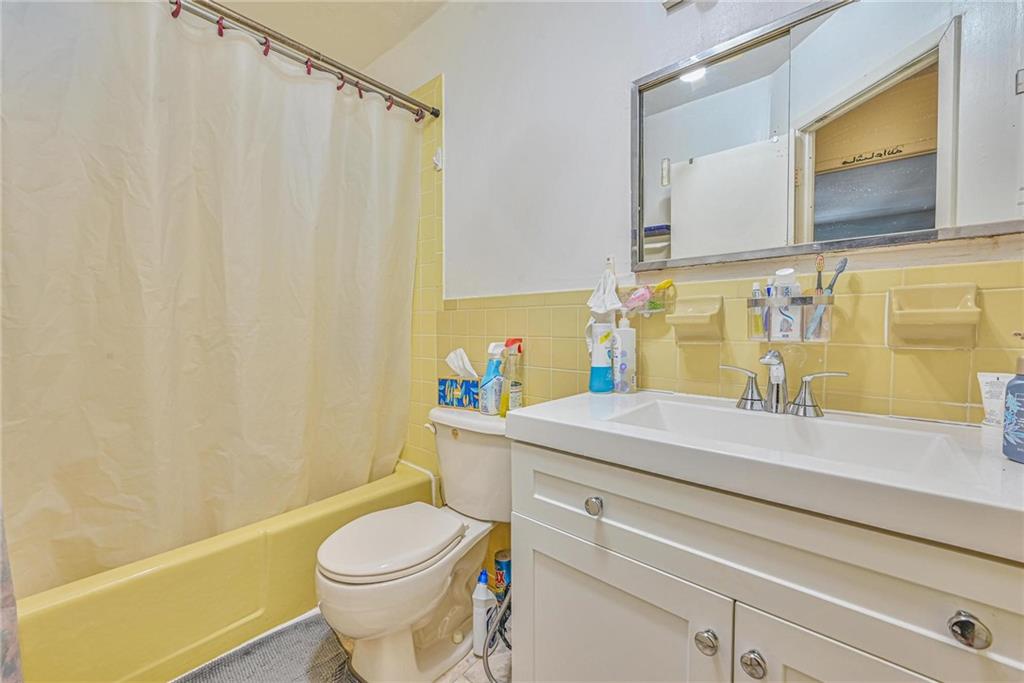 237 74th Street Brooklyn, NY 11209 - Photo 9 of 20 a bathroom with a sink a toilet and a mirror