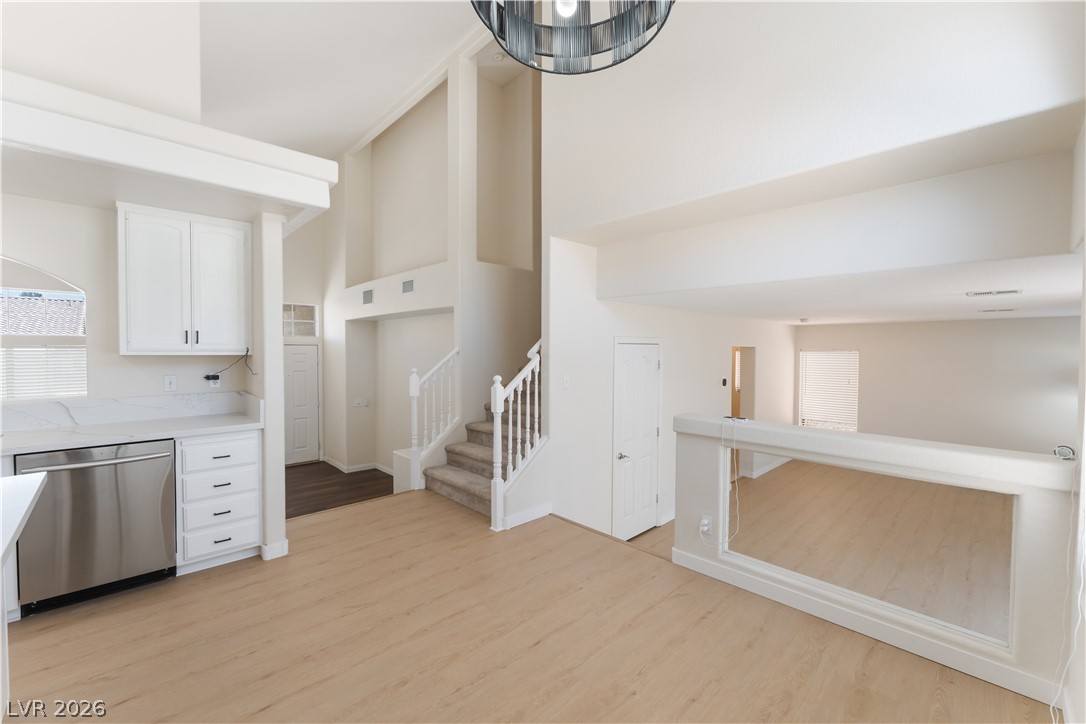 8872 Chapman Point Las Vegas, NV 89129 - Photo 28 of 29 A spacious, airy interior features high ceilings and a flowing floorplan, uniting living spaces with an elegant staircase.