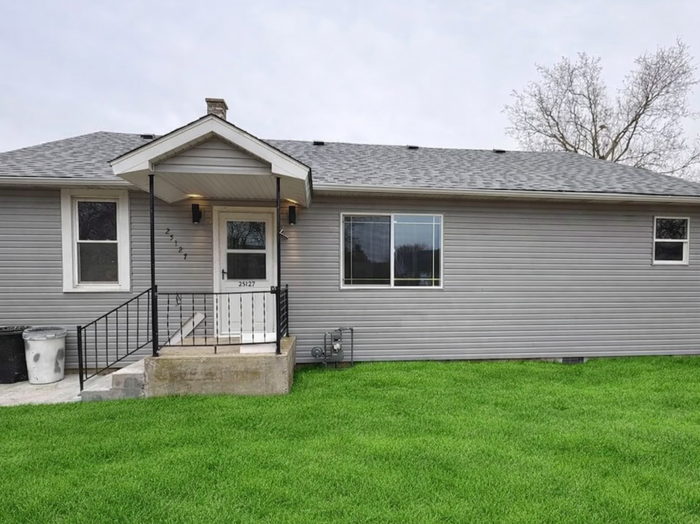 a front view of a house with a garden