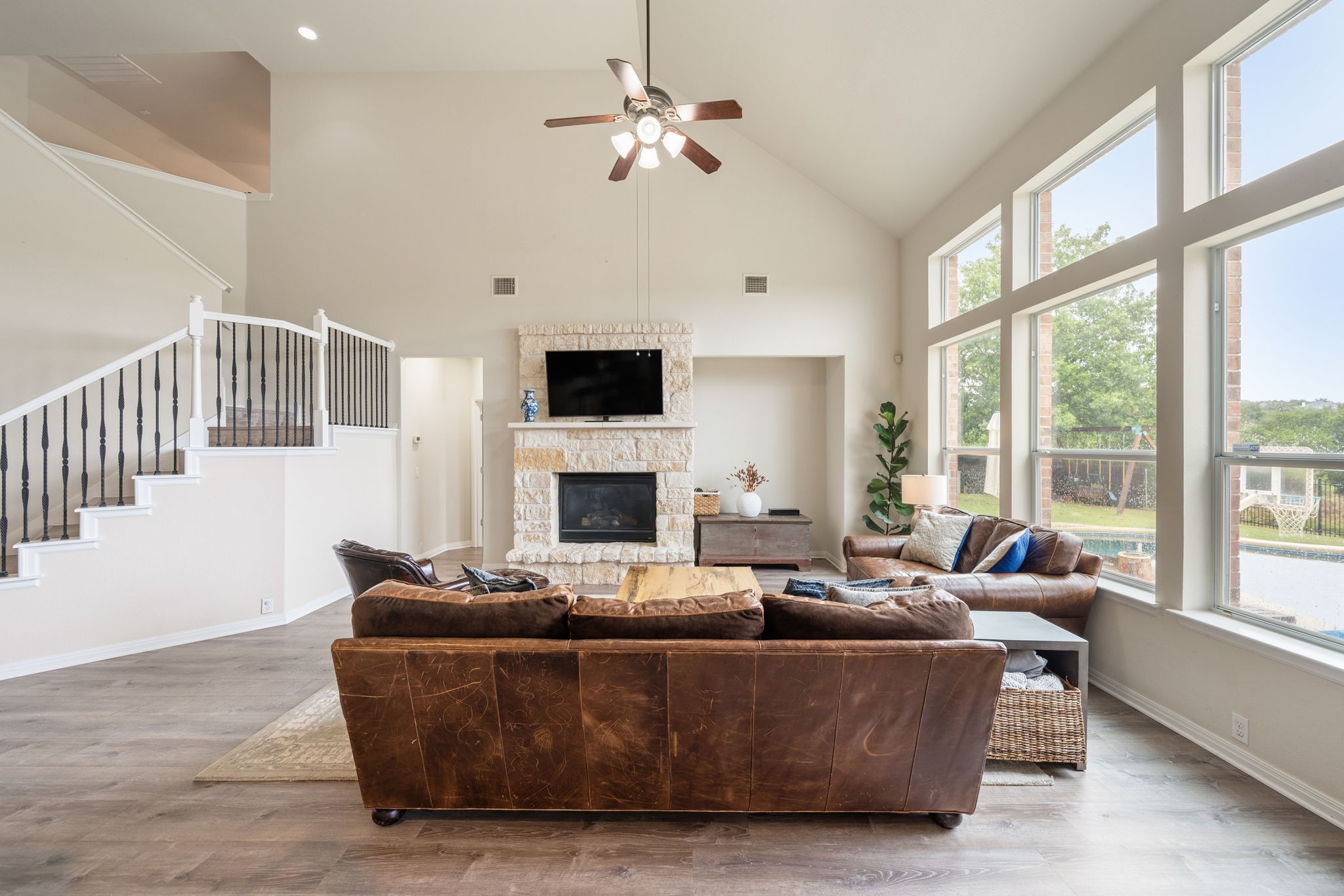 1581 Grassy Field Road Austin, TX 78737 - Photo 9 of 37 Soaring vaulted ceilings and a stone fireplace anchor this light-filled room with backyard views.
