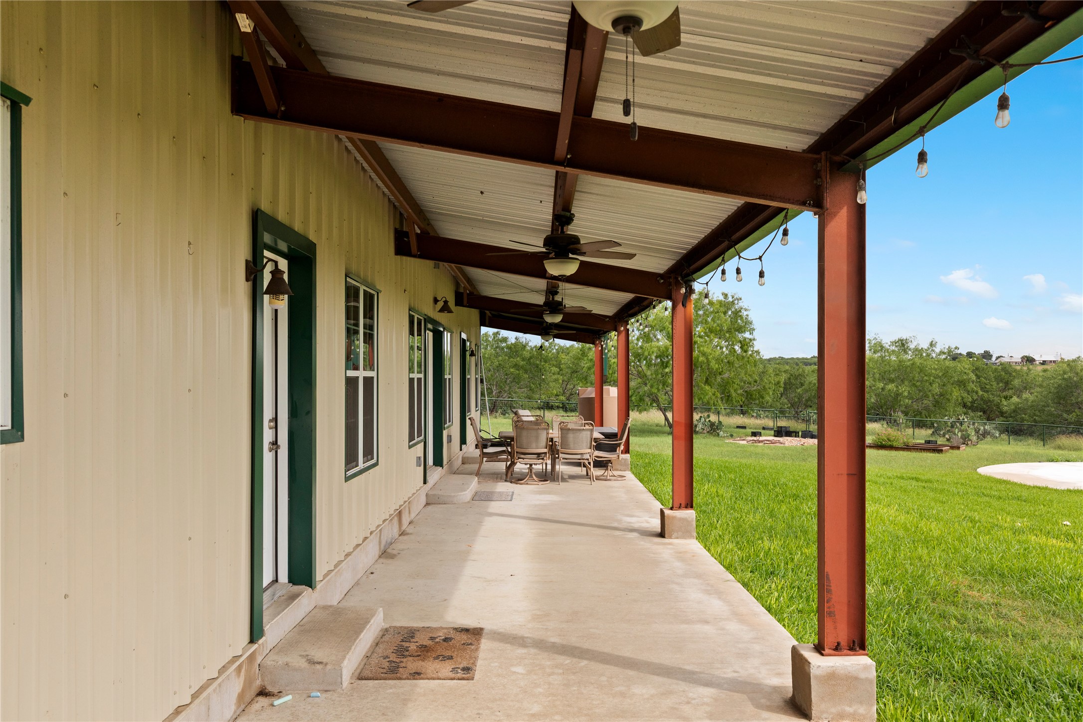 1293 Pioneer Road Seguin, TX 78155 - Photo 40 of 40 Enjoy outdoor living with a spacious covered patio and expansive green yard, perfect for relaxation or entertaining.