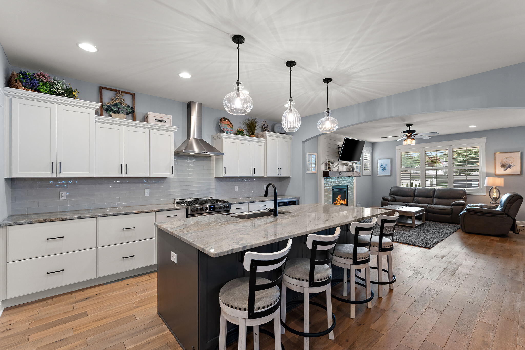 5956 Beacon Lane Portage, IN 46368 - Photo 13 of 57 a kitchen with granite countertop a stove a sink a dining table and chairs with wooden floor