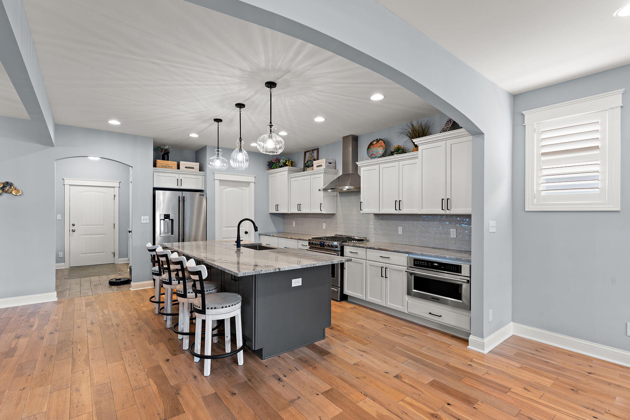 5956 Beacon Lane Portage, IN 46368 - Photo 10 of 57 a kitchen with stainless steel appliances granite countertop a stove top oven a refrigerator a sink and a dining table with wooden floor