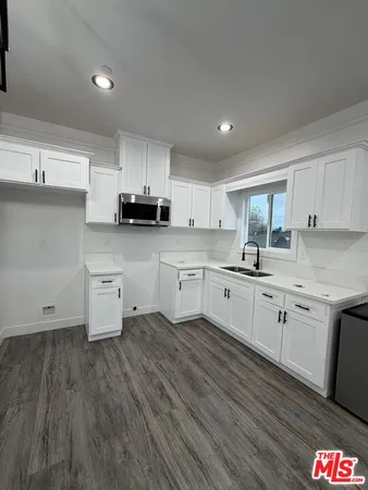 a large kitchen with kitchen island granite countertop a large counter top and wooden floors