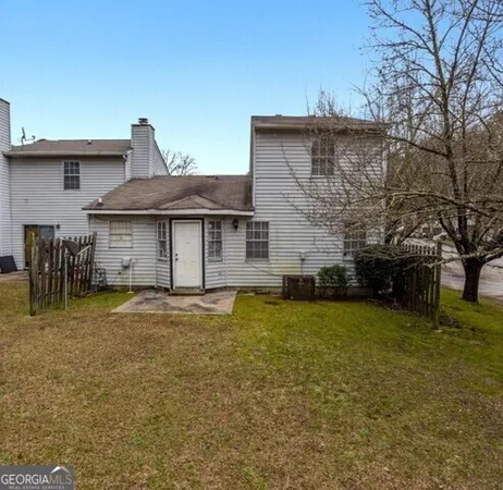 a front view of a house with a garden and trees