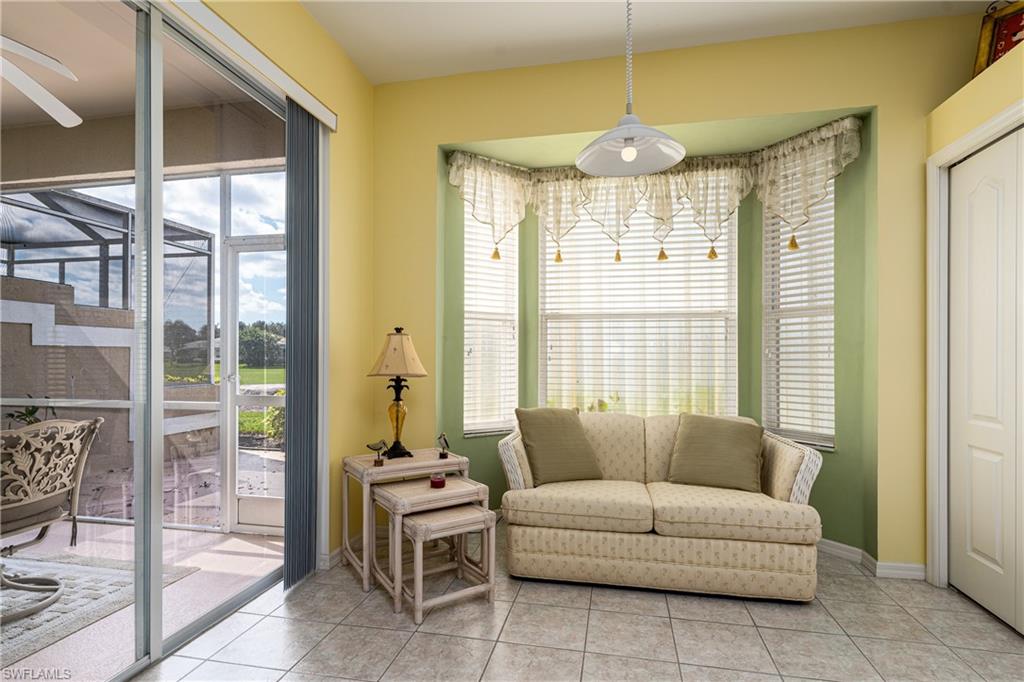1927 Morning Sun Lane, Unit F27 Naples, FL 34119 - Photo 11 of 17 a living room with furniture and a chandelier