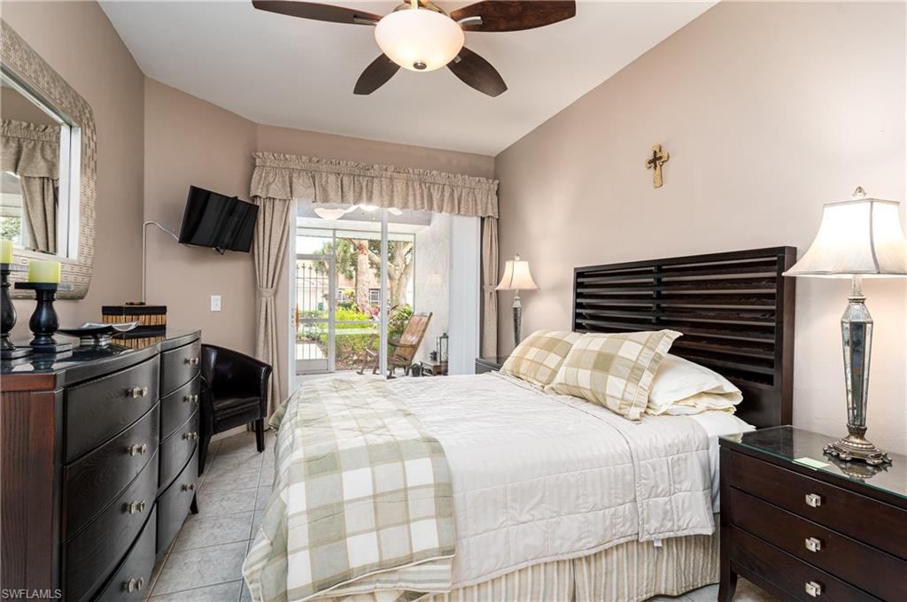1927 Morning Sun Lane, Unit F27 Naples, FL 34119 - Photo 12 of 17 a bedroom with a bed and a flat tv screen
