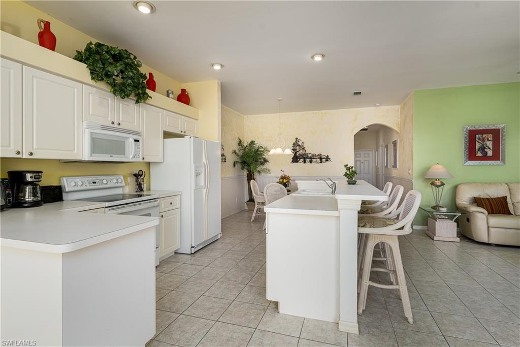 1927 Morning Sun Lane, Unit F27 Naples, FL 34119 - Photo 8 of 17 a kitchen view with table and chairs