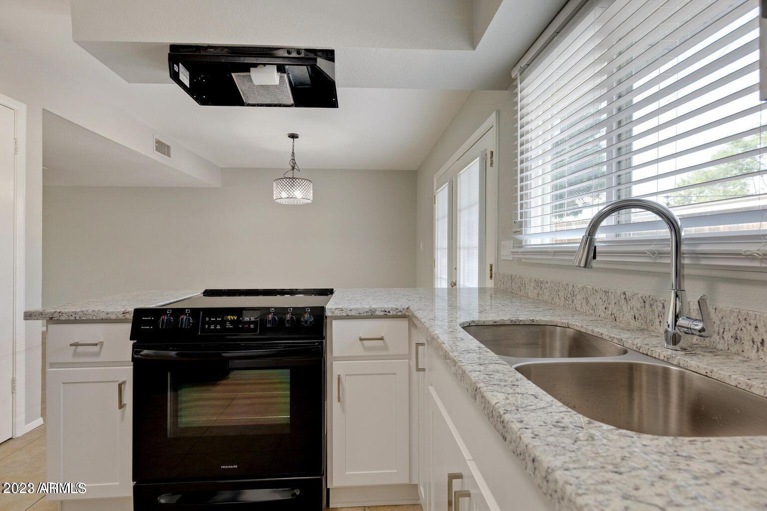 6617 South Granada Drive Tempe, AZ 85283 - Photo 18 of 20 a kitchen with a stove and a sink