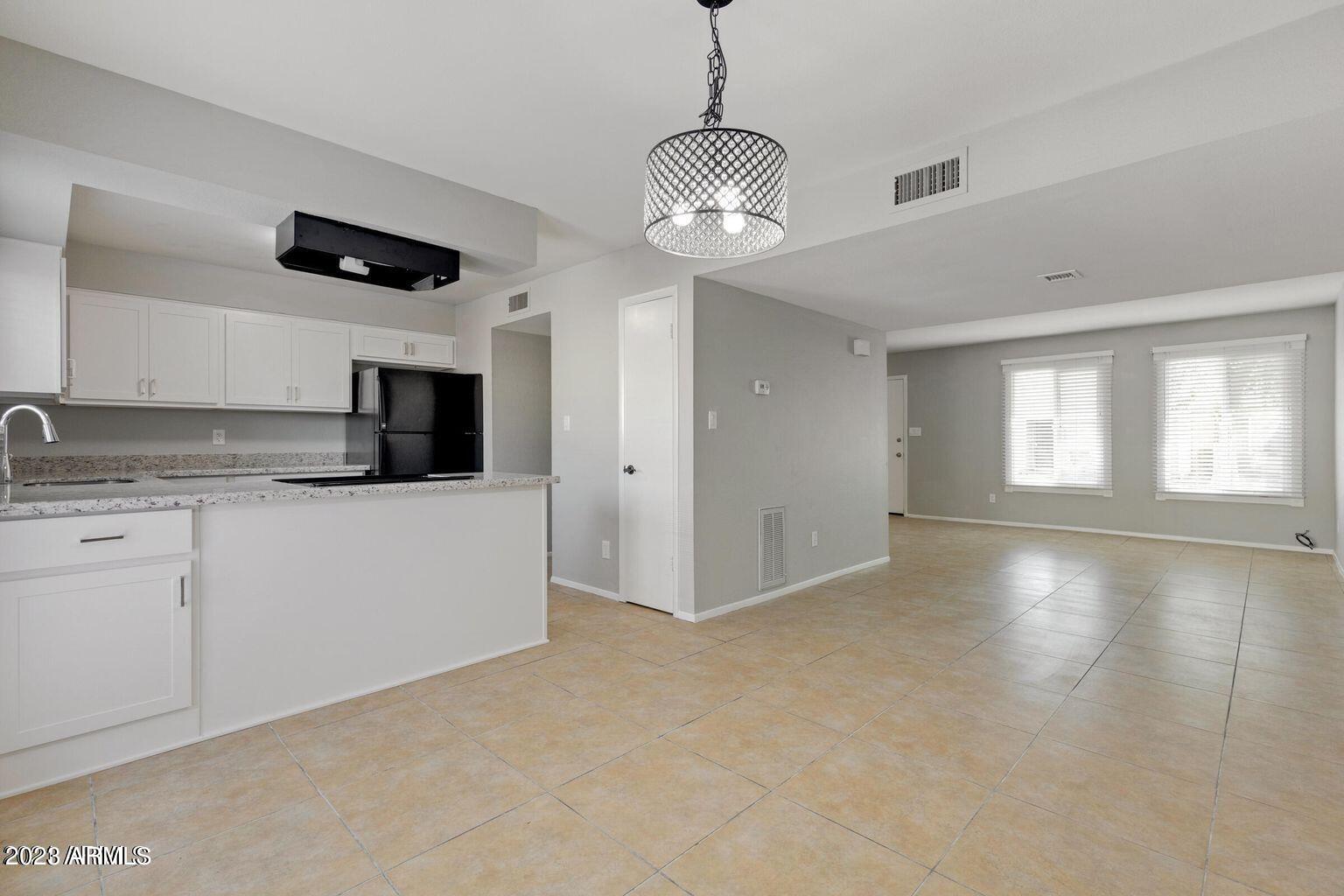 6617 South Granada Drive Tempe, AZ 85283 - Photo 19 of 20 a view of an empty room with window and kitchen view