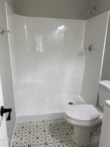 a bathroom with a toilet and a shower