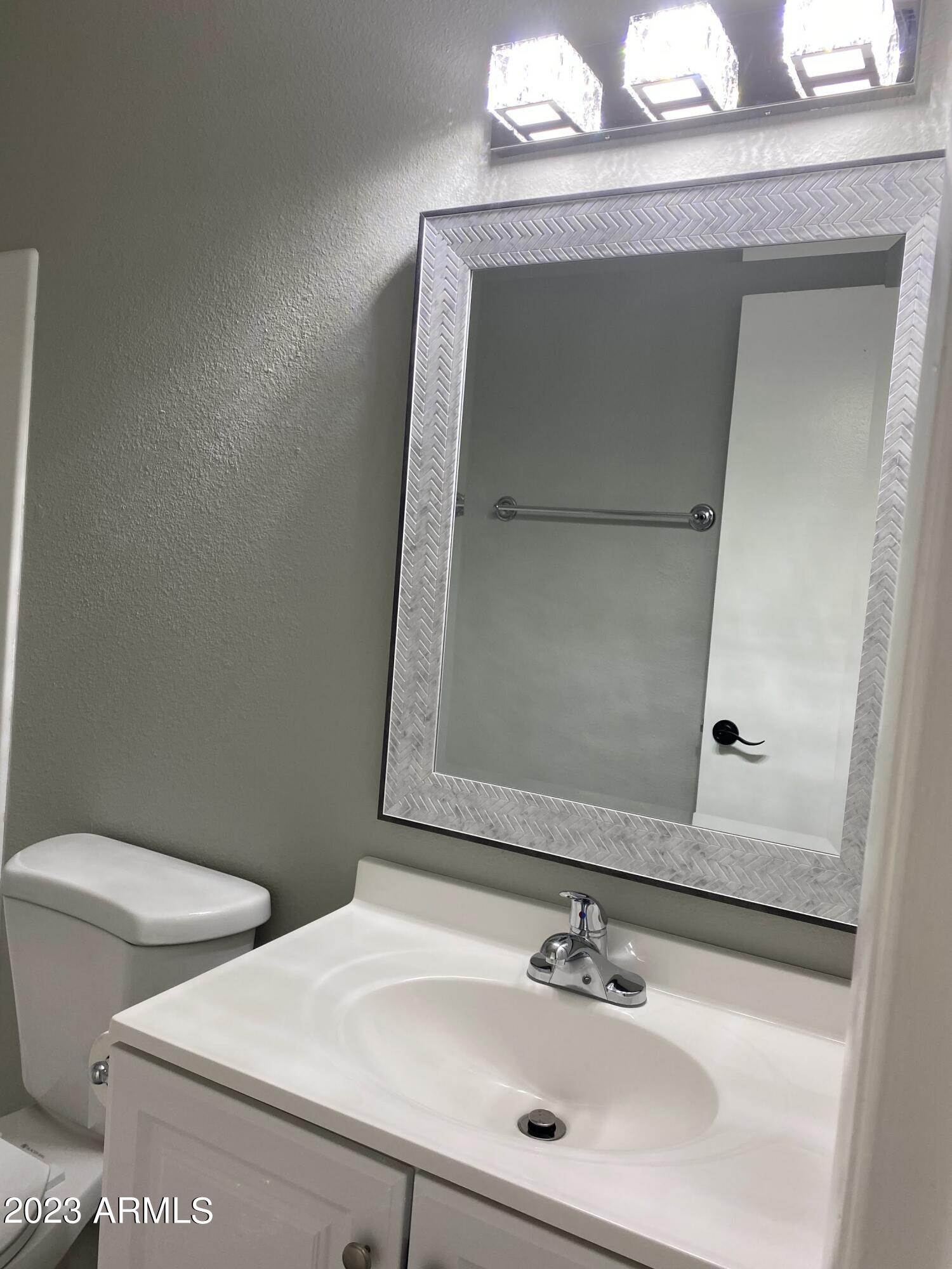 6617 South Granada Drive Tempe, AZ 85283 - Photo 9 of 20 a bathroom with a toilet sink and mirror