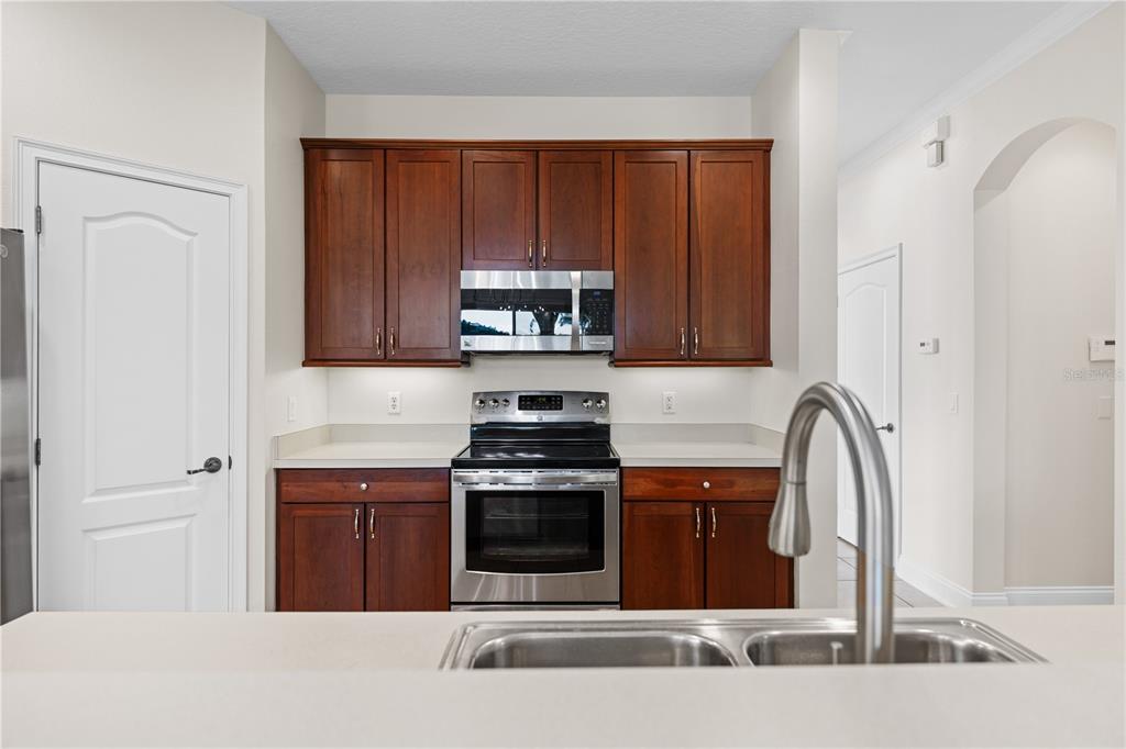 7224 Halton Court Windermere, FL 34786 - Photo 11 of 50 a kitchen with a stove a sink and a microwave