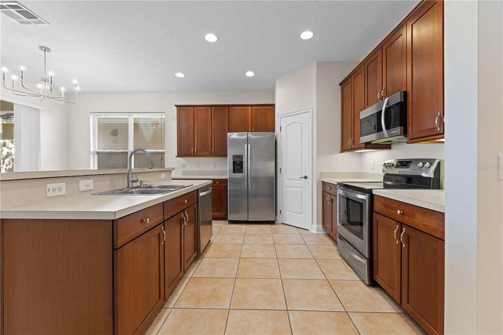 7224 Halton Court Windermere, FL 34786 - Photo 9 of 50 a large kitchen with stainless steel appliances granite countertop a sink counter space cabinets and a large window