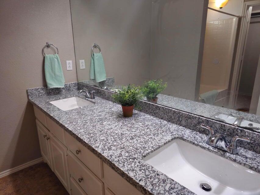 1918 75th Street Lubbock, TX 79423 - Photo 11 of 14 a bathroom with a granite countertop sink and a mirror