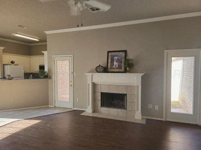 a view of a livingroom with wooden floor and a fireplace