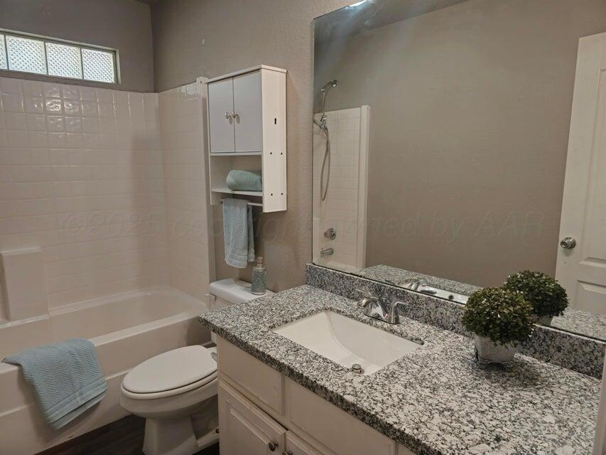 1918 75th Street Lubbock, TX 79423 - Photo 9 of 14 a bathroom with a granite countertop sink toilet and shower