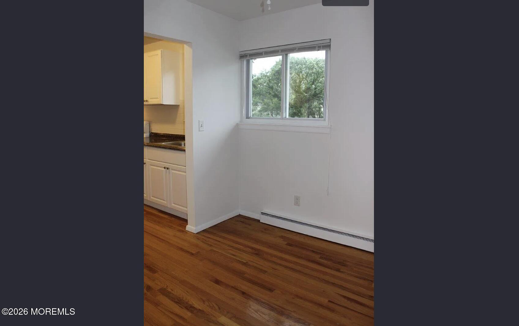 711 Wall Road, Unit 2 Spring Lake Heights, NJ 07762 - Photo 8 of 12 an empty room with wooden floor and windows