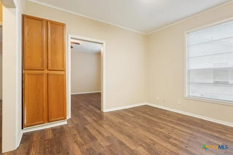 an empty room with wooden floor and a window