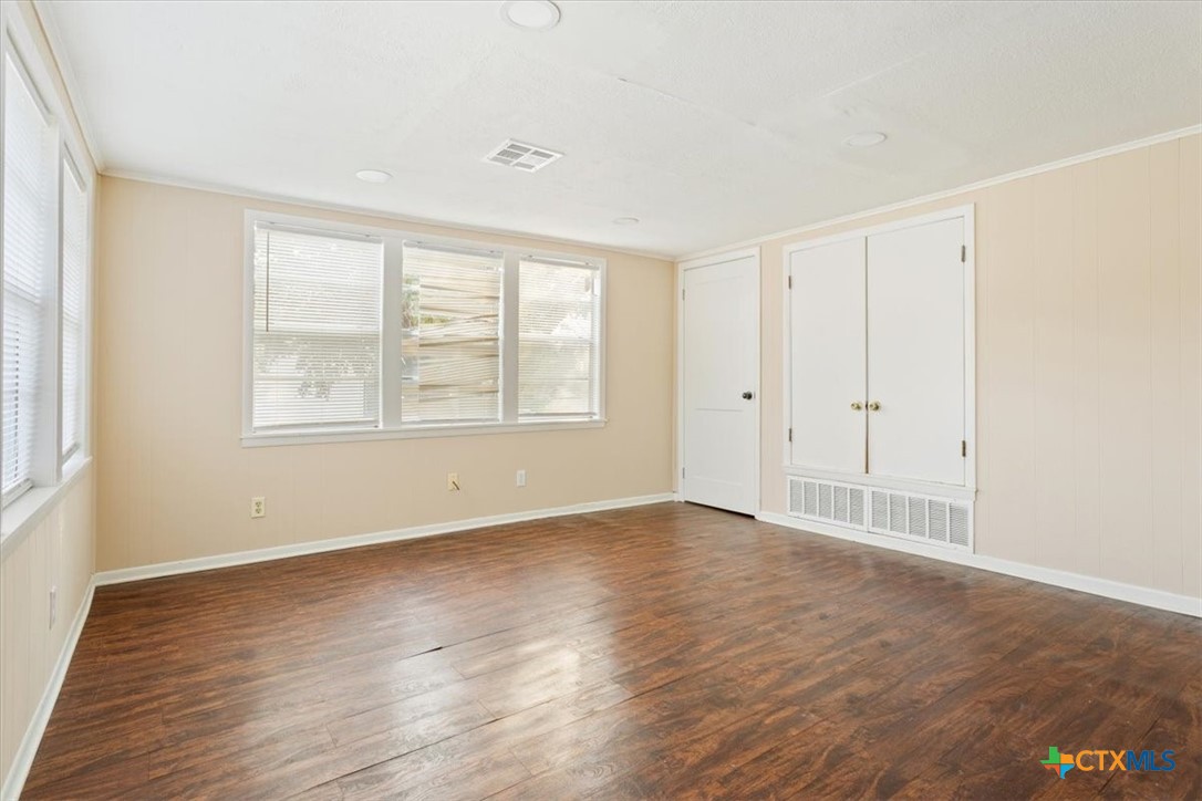 1219 South 17th Street Temple, TX 76504 - Photo 13 of 24 an empty room with wooden floor and windows