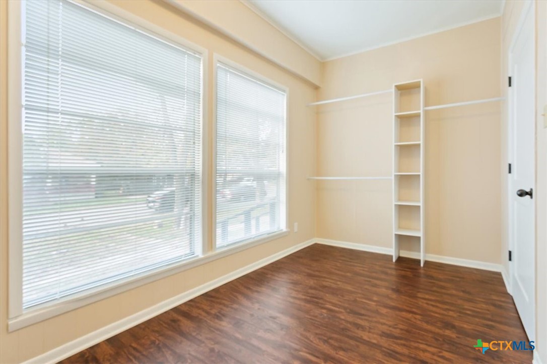 1219 South 17th Street Temple, TX 76504 - Photo 20 of 24 a view of an empty room with wooden floor and a window