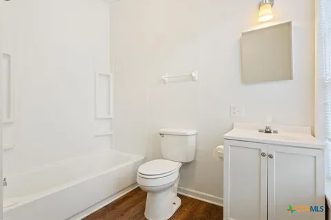 a bathroom with a toilet a sink a mirror and bathtub