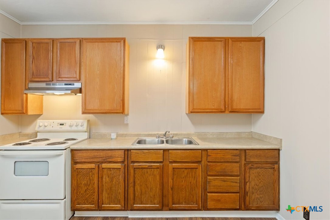 1219 South 17th Street Temple, TX 76504 - Photo 9 of 24 a kitchen with granite countertop cabinets sink and wooden floor