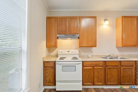 a kitchen with granite countertop cabinets stainless steel appliances and a sink