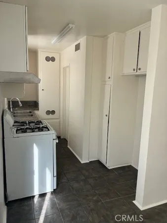 a kitchen with granite countertop a refrigerator and a stove