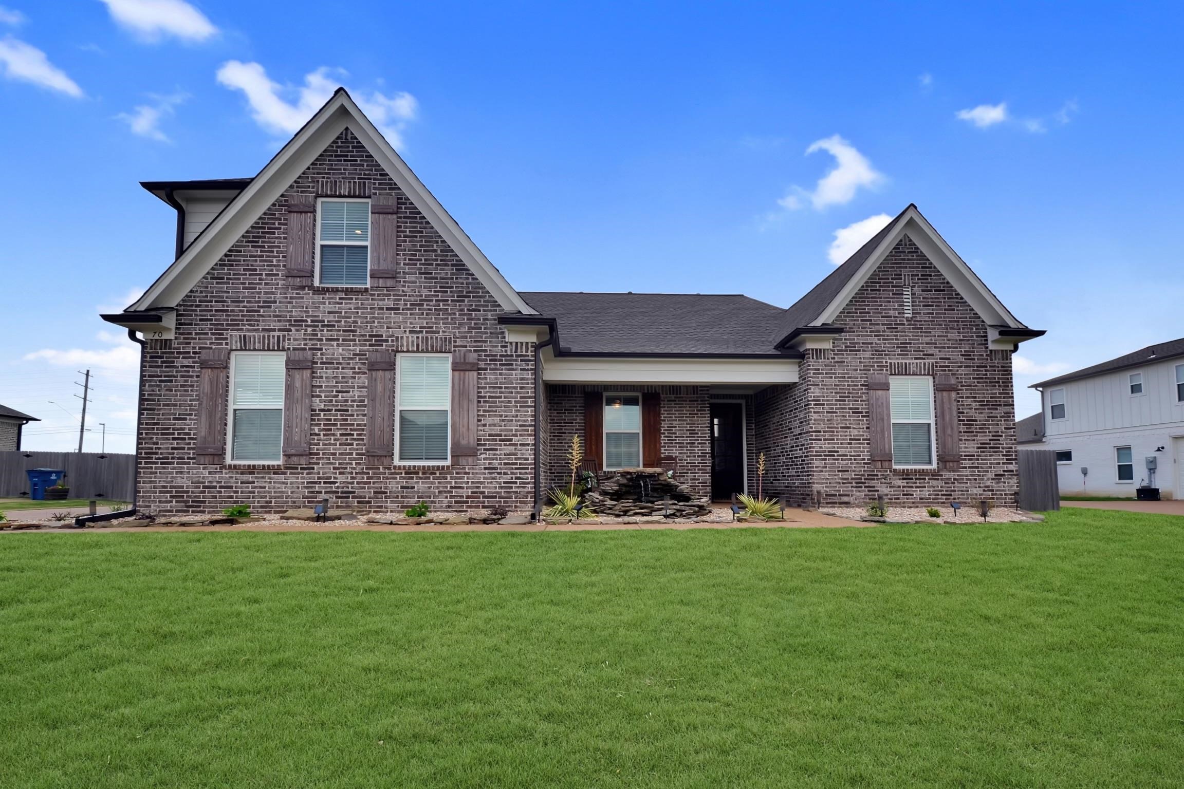 a front view of a house with a yard and trees