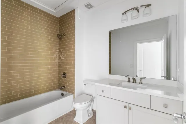 a bathroom with a sink a toilet a mirror a bathtub and shower