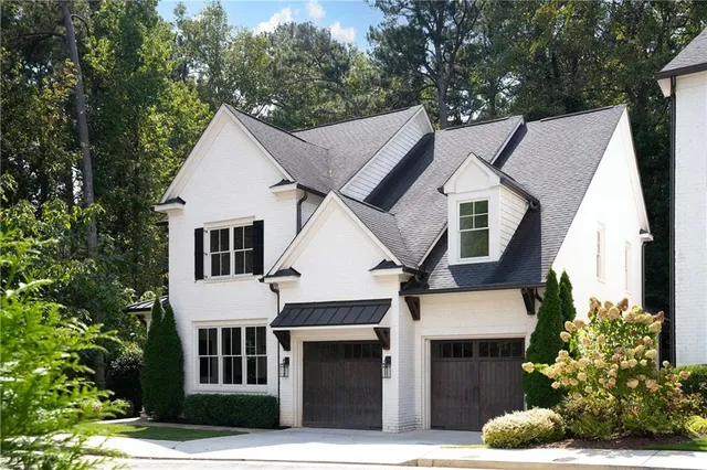 a view of a white house with large windows and a large tree