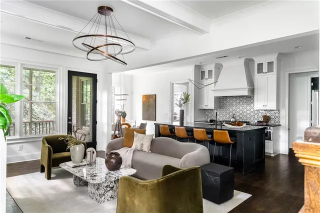 a living room with furniture kitchen view and large windows