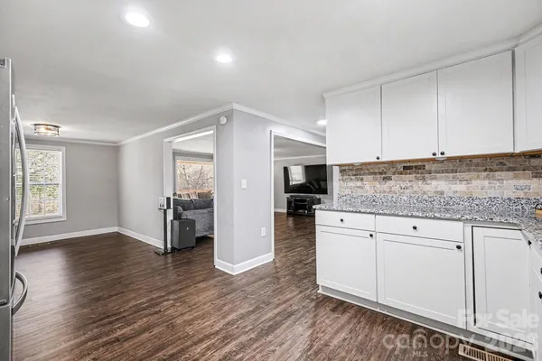 a kitchen with granite countertop a stove a sink and a refrigerator