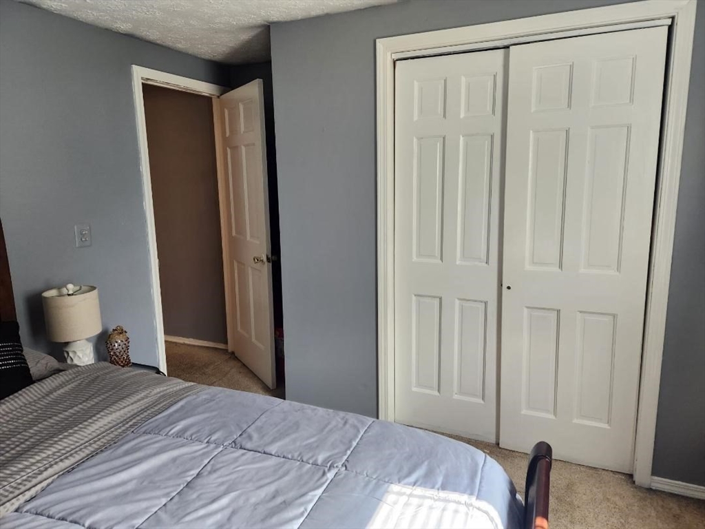 21 Brattle Street Worcester, MA 01606 - Photo 3 of 14 a bedroom with a bed and a chair