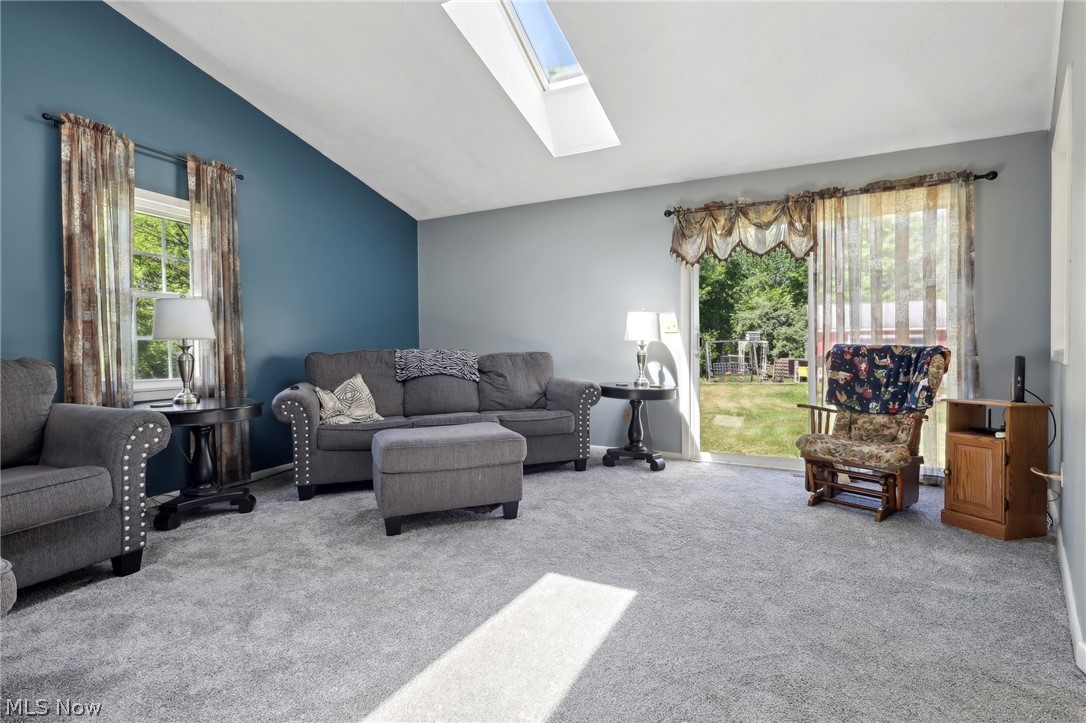 16146 Ravenna Road Burton, OH 44021 - Photo 7 of 27 Carpeted living room featuring lofted ceiling with skylight