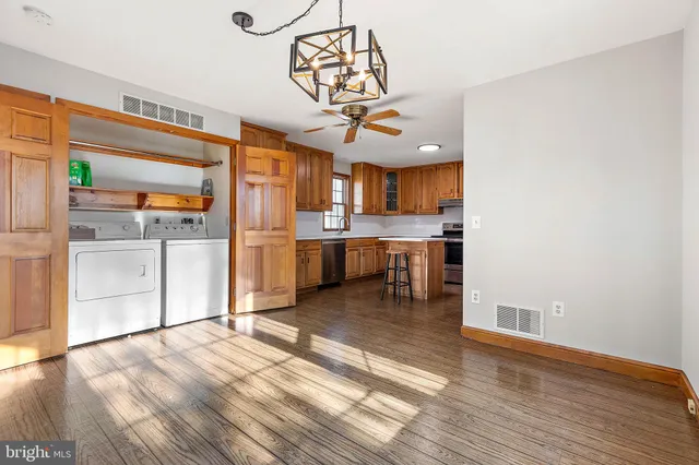 a view of a kitchen with a sink wooden cabinets and stainless steel appliances