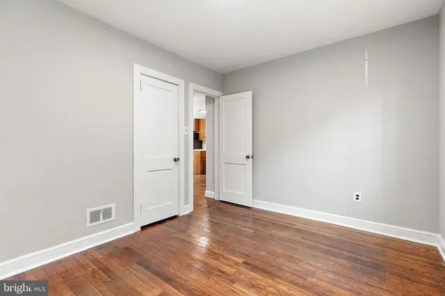 a view of an empty room with wooden floor