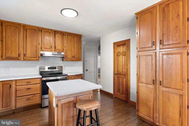 a kitchen with stainless steel appliances granite countertop white cabinets and wooden floor